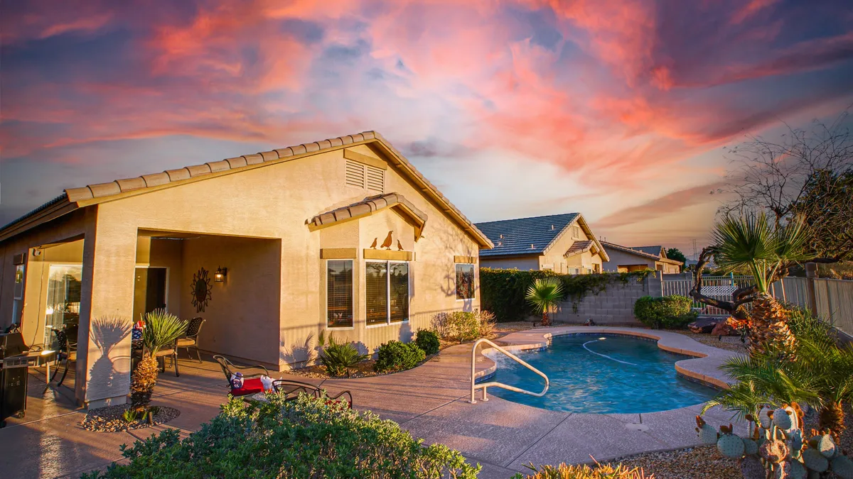 A sunlit exterior showcases a sparkling swimming pool surrounded by a landscaped garden, outdoor seating area, and inviting patio. The space exudes a cheerful, resort-like atmosphere ideal for swimming, entertaining, and relaxing outdoors with family and friends.