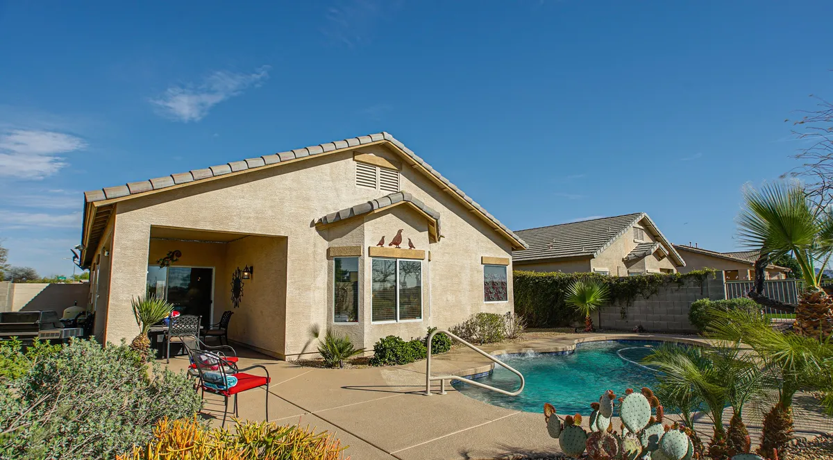 Featuring a sparkling swimming pool set amid a landscaped garden, this image highlights an outdoor seating area perfect for dining or relaxing. The setting captures the sense of spaciousness, comfort, and versatility, making it ideal for gatherings, outdoor meals, or simply unwinding with loved ones.